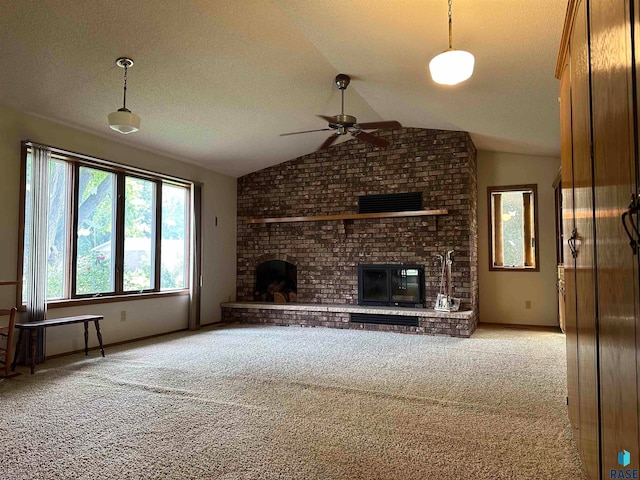 unfurnished living room featuring brick wall, a fireplace, ceiling fan, carpet flooring, and vaulted ceiling