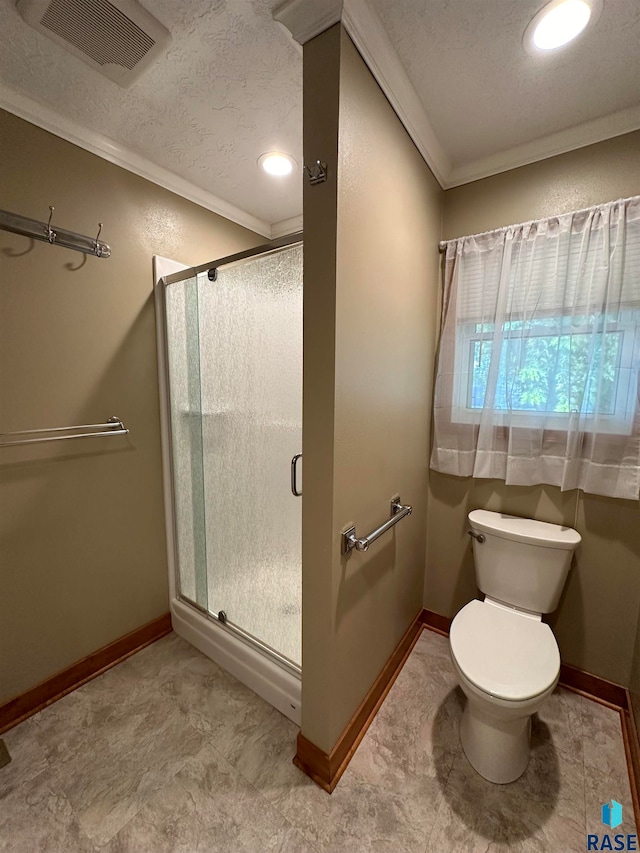 bathroom featuring crown molding, tile patterned floors, a textured ceiling, toilet, and walk in shower