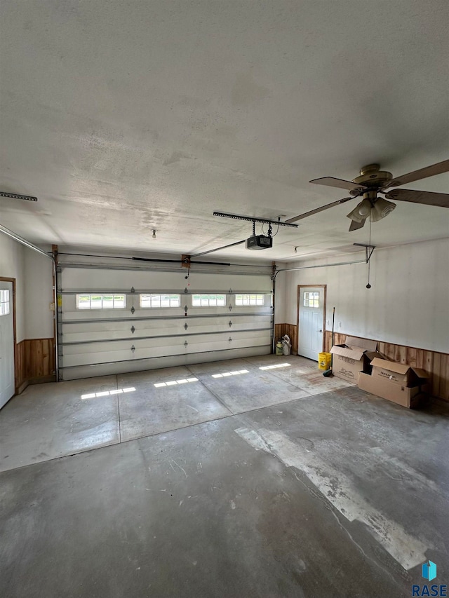 garage with ceiling fan and a garage door opener