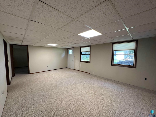 basement with light colored carpet and a paneled ceiling