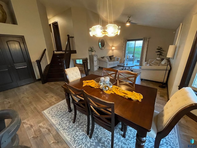 dining space featuring an inviting chandelier, light hardwood / wood-style floors, and lofted ceiling