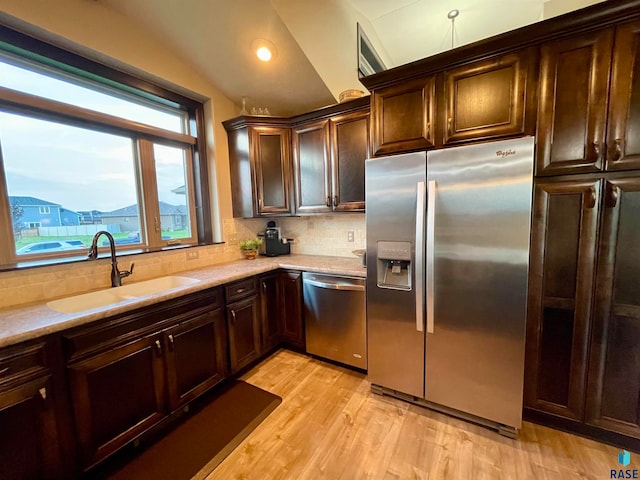 kitchen featuring light hardwood / wood-style flooring, backsplash, dark brown cabinetry, appliances with stainless steel finishes, and sink