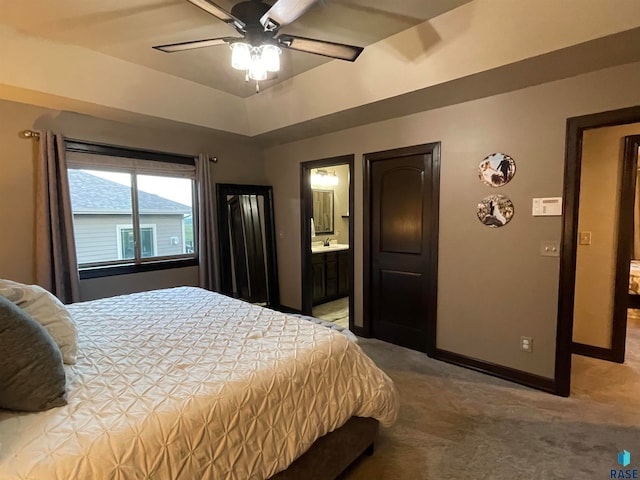 bedroom with ceiling fan, light carpet, ensuite bath, and sink