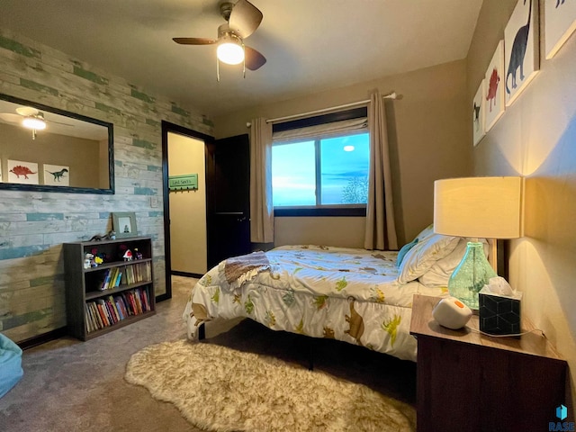 carpeted bedroom with wooden walls and ceiling fan