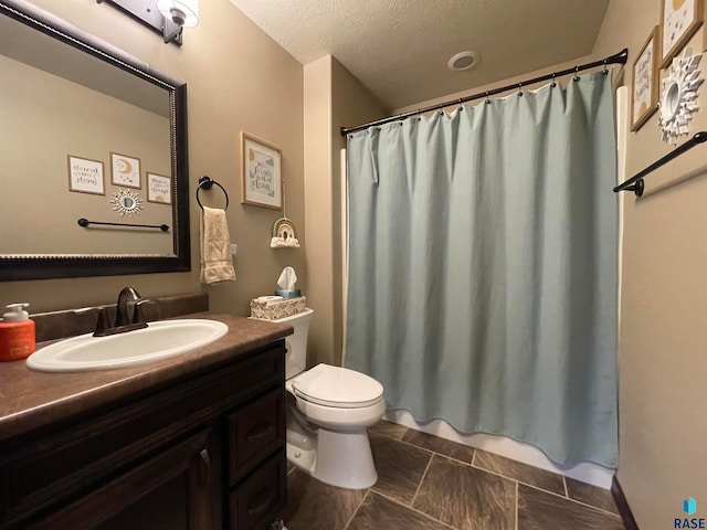 bathroom with tile patterned floors, a textured ceiling, a shower with shower curtain, vanity, and toilet