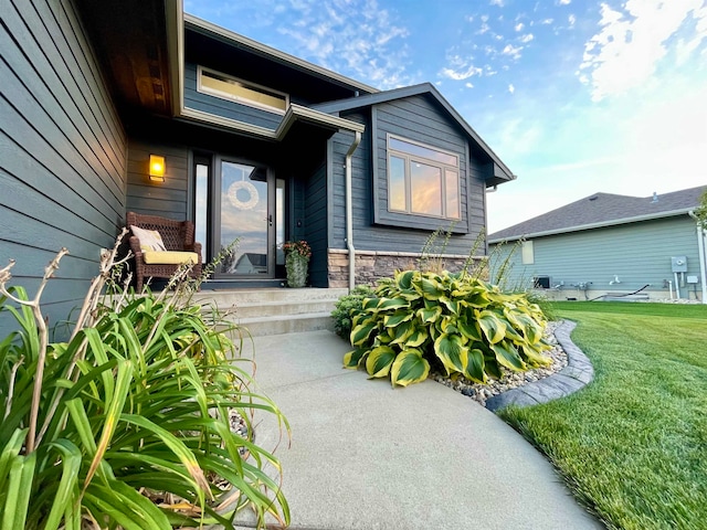 property entrance with a lawn