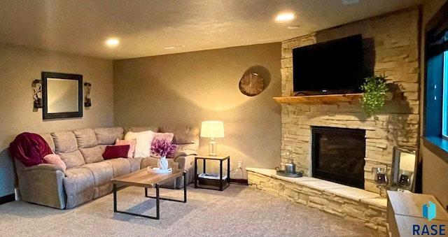 carpeted living room featuring a stone fireplace