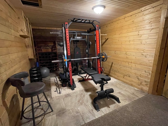 exercise area with wood ceiling and wooden walls