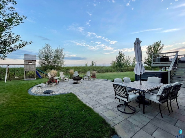 exterior space featuring a playground, a fire pit, and a patio