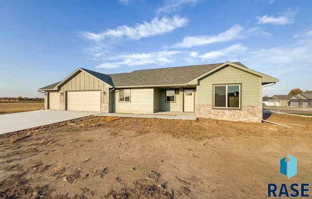 ranch-style home featuring an attached garage, board and batten siding, driveway, and stone siding