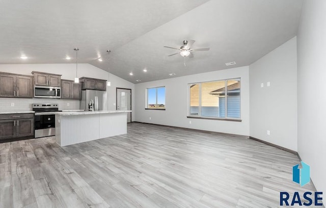 kitchen featuring light countertops, stainless steel appliances, open floor plan, a ceiling fan, and lofted ceiling