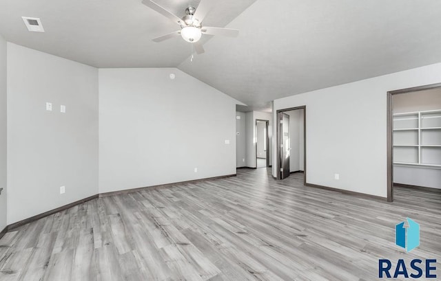 unfurnished living room with a ceiling fan, baseboards, wood finished floors, lofted ceiling, and visible vents