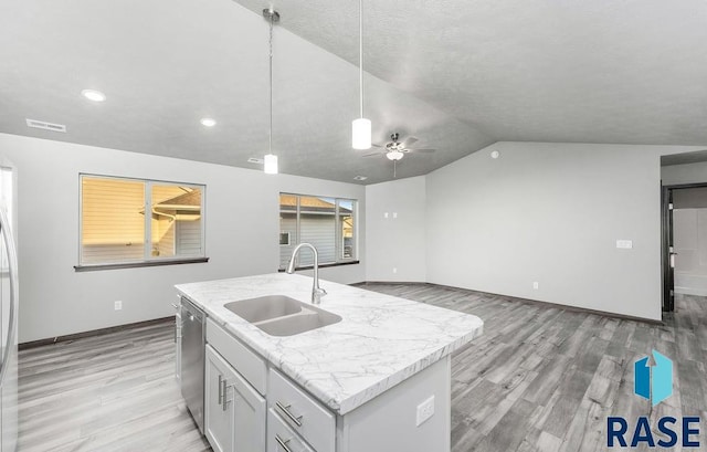 kitchen with an island with sink, light wood-type flooring, vaulted ceiling, dishwasher, and sink