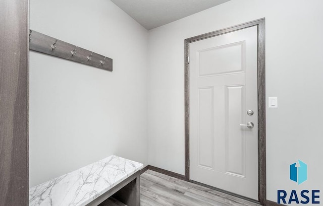 mudroom featuring baseboards and light wood finished floors