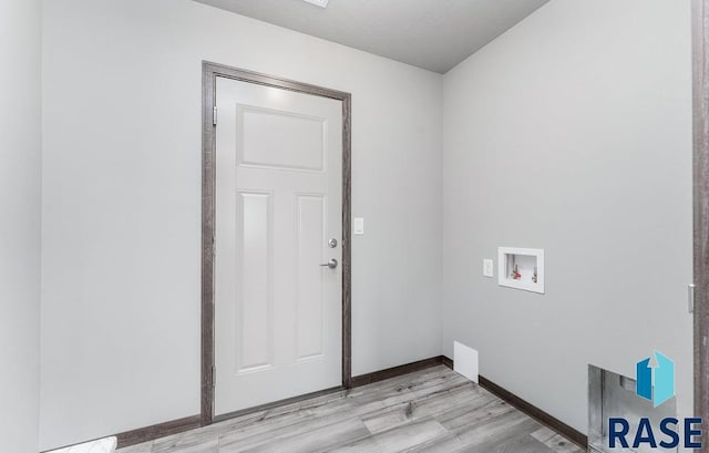 clothes washing area featuring light wood-style floors, baseboards, laundry area, and hookup for a washing machine
