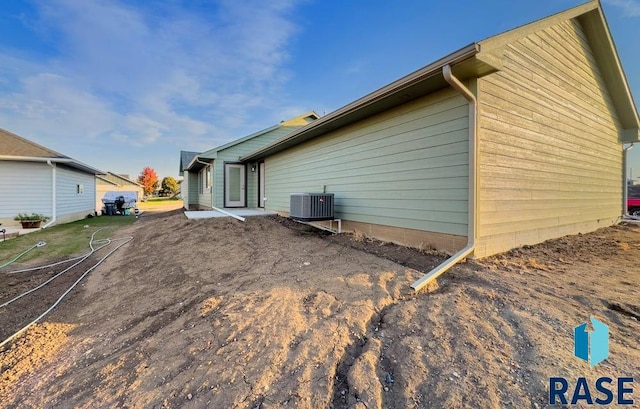 view of side of property with a patio and central AC unit