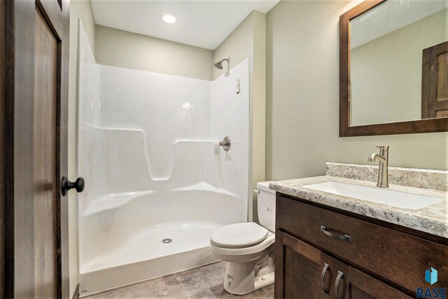 bathroom featuring vanity, toilet, a shower, and tile patterned floors