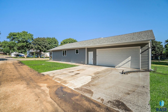 ranch-style house with concrete driveway, a front lawn, and an attached garage