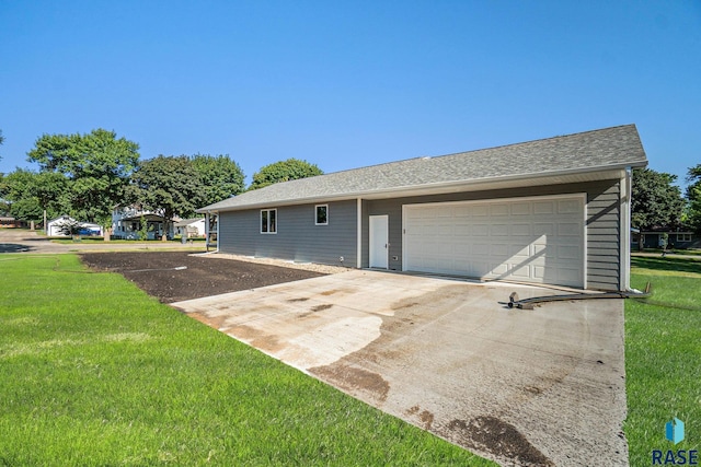 view of front facade with a garage, a front yard, driveway, and a shingled roof