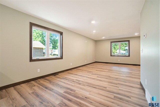 unfurnished room featuring a healthy amount of sunlight and light hardwood / wood-style floors