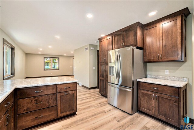 kitchen with dark brown cabinets, light hardwood / wood-style floors, and stainless steel refrigerator with ice dispenser