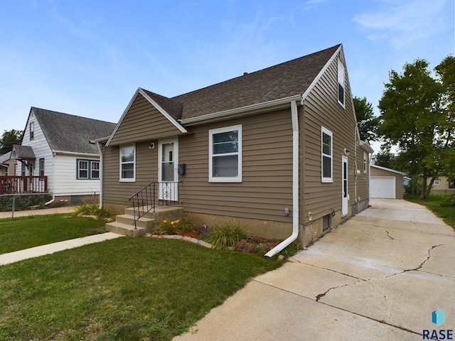 view of front of home with an outbuilding, a garage, and a front lawn