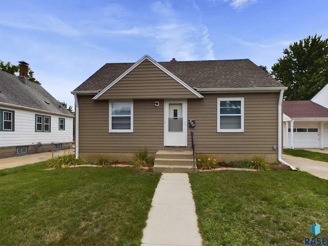 bungalow-style home with a garage and a front lawn