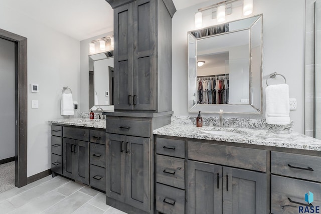 full bathroom featuring a spacious closet, baseboards, and vanity