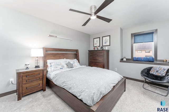 bedroom featuring ceiling fan, baseboards, and light colored carpet