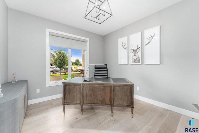 office area featuring light wood-type flooring, baseboards, and a chandelier