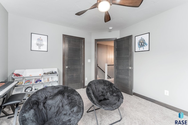 living area featuring a ceiling fan, carpet, an upstairs landing, and baseboards