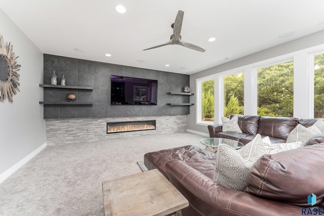 living room featuring baseboards, a ceiling fan, a glass covered fireplace, carpet floors, and recessed lighting