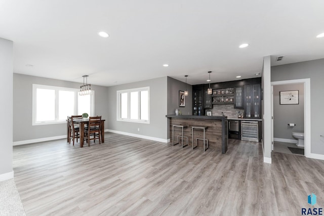 interior space featuring recessed lighting, wood finished floors, glass insert cabinets, and baseboards