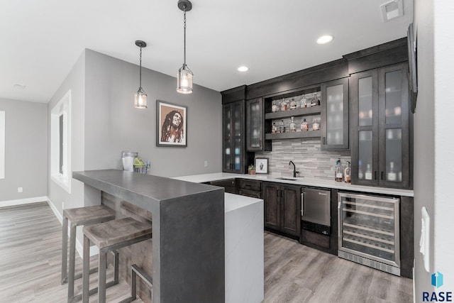 bar with wine cooler, a sink, visible vents, wet bar, and decorative light fixtures