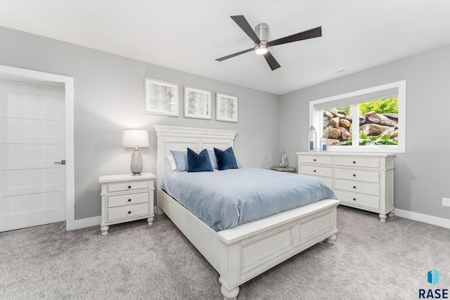 bedroom featuring light carpet, ceiling fan, and baseboards