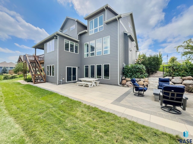 rear view of property featuring a patio area, stairs, fence, and a yard