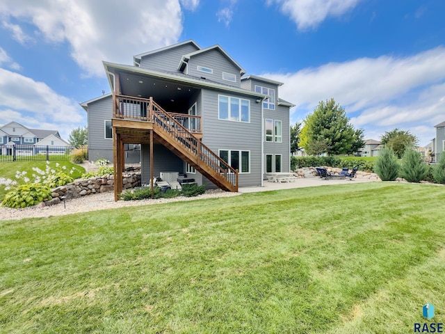 rear view of house with a lawn, stairway, fence, a wooden deck, and a patio area