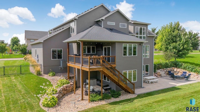 back of house featuring a lawn, stairway, fence, a wooden deck, and a patio area