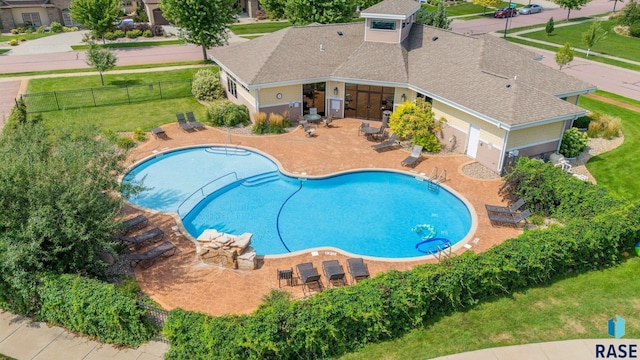 pool with fence, a lawn, and a patio