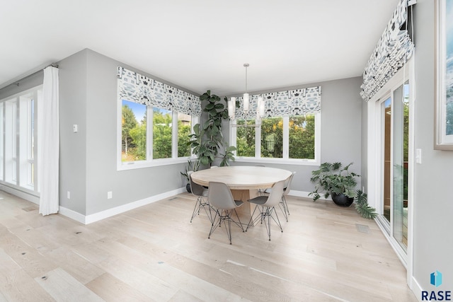 dining room featuring light wood-type flooring and baseboards