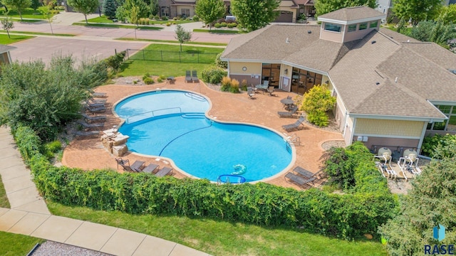 view of swimming pool featuring fence, a lawn, and a patio