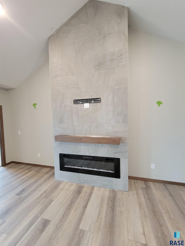 interior details with a large fireplace, baseboards, and wood finished floors