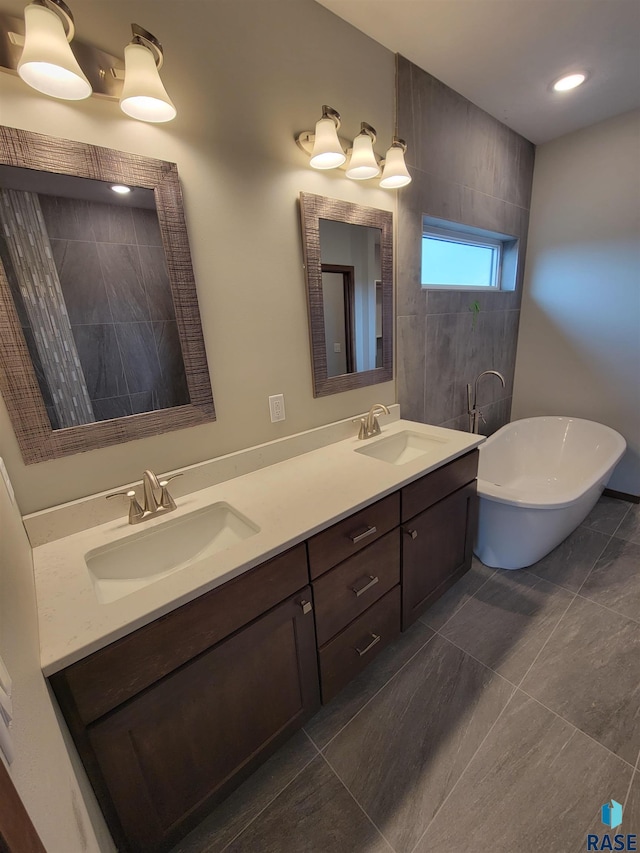 full bath featuring a freestanding bath, double vanity, and a sink