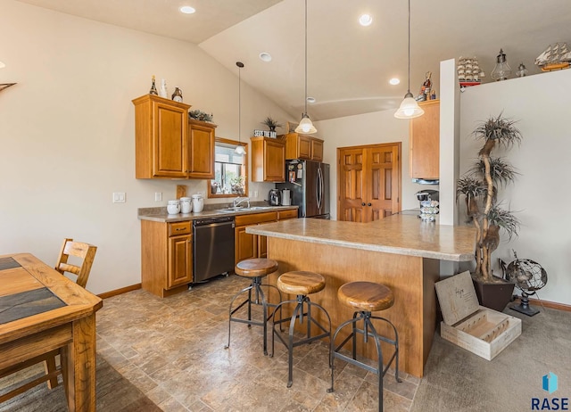 kitchen featuring a breakfast bar area, pendant lighting, stainless steel appliances, sink, and lofted ceiling