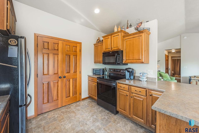 kitchen featuring appliances with stainless steel finishes, vaulted ceiling, and kitchen peninsula