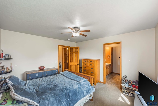 carpeted bedroom with a textured ceiling, connected bathroom, and ceiling fan