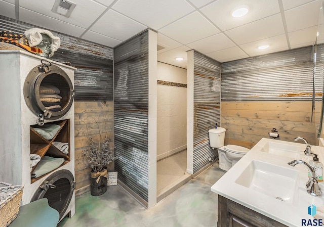 bathroom with toilet, a drop ceiling, concrete floors, and vanity