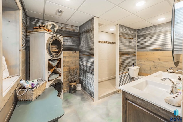 bathroom featuring wooden walls, concrete floors, a shower, a paneled ceiling, and vanity