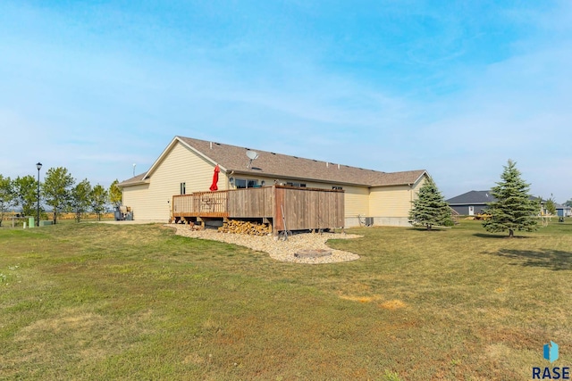 back of property featuring a lawn and a wooden deck