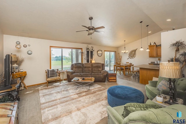 living room with lofted ceiling, ceiling fan with notable chandelier, and light colored carpet